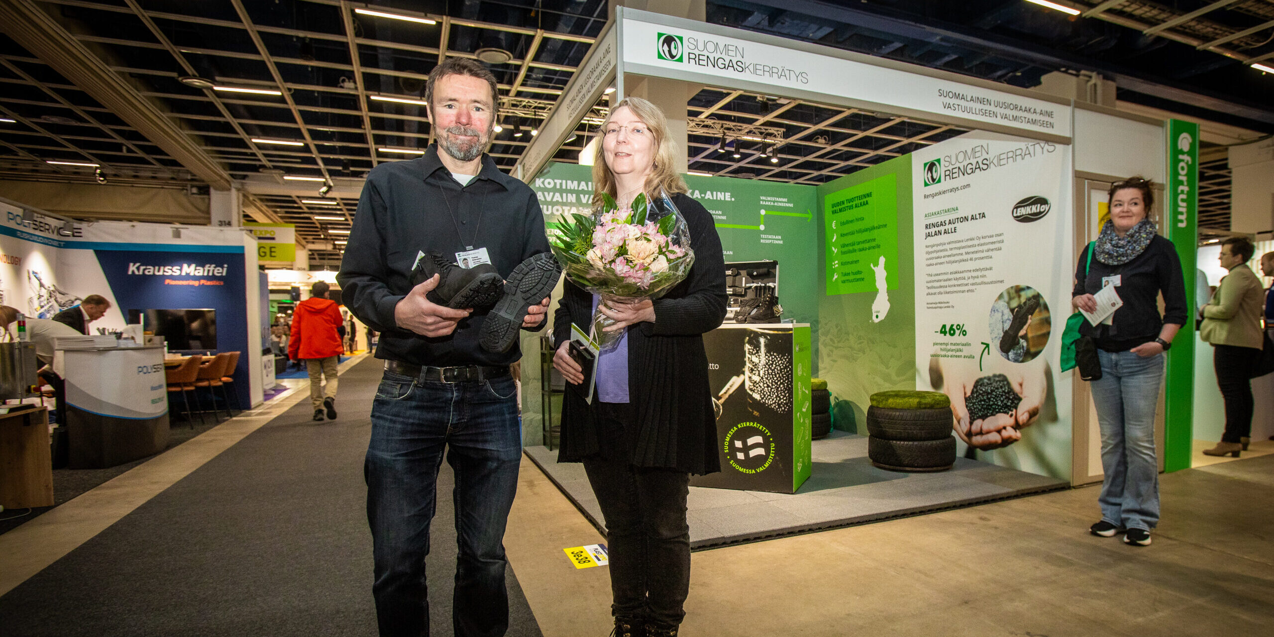 Thomas Söderström ja Annamaija Mäkilouko seisovat Suomen Rengaskierrätyksen ständin edessä messuilla.